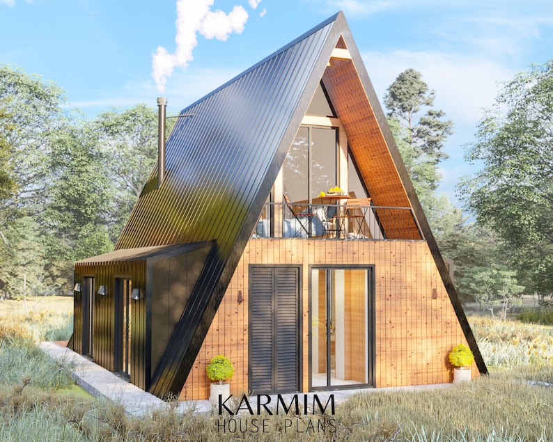 May include: A modern, black-roofed A-frame house with a wooden exterior and a balcony. The house has large windows and a door with a glass panel. The house is surrounded by trees and grass.