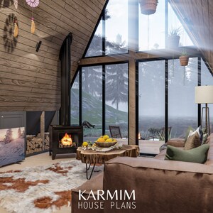 May include: A cozy living room with a large window overlooking a snowy forest. The room features a wood-burning stove, a leather sofa, a coffee table, and a television. The text "KARMIM HOUSE PLANS" is visible in the bottom right corner of the image.