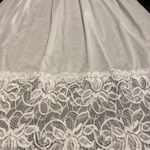 Può includere: Slip bianco con bordo in pizzo. Il pizzo è un delicato motivo floreale.