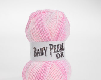 Könnte beinhalten: Eine Knäuel rosa und weißes Garn mit einem Etikett mit der Aufschrift "Baby Pebble DK".