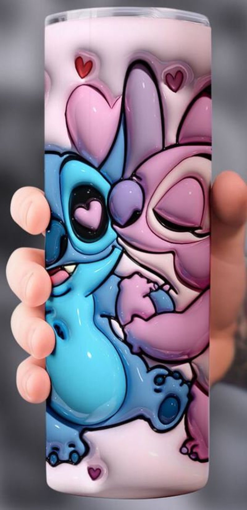 Puede incluir: Un personaje de dibujos animados rosa y azul con ojos grandes y una gran sonrisa. El personaje sostiene un coraz&oacute;n en su mano. El fondo es rosa con corazones.