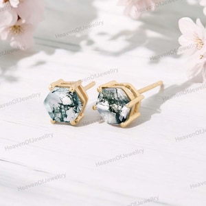 May include: A pair of gold hexagonal stud earrings with a clear, green, and white dendritic agate stone in each earring.