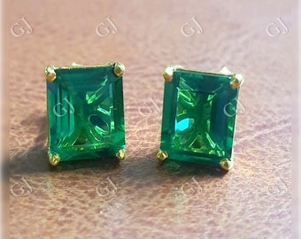 Pode incluir: Um par de brincos quadrados de cor verde esmeralda com engastes de ouro.