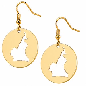 May include: A pair of gold-toned dangle earrings featuring circular discs. Each disc has a cutout in the center shaped like the map of Cameroon. The earrings are attached to standard gold-toned fishhook ear wires for hanging from the earlobe.