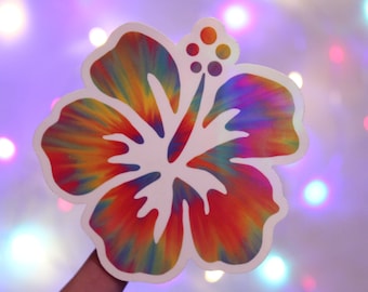 May include: A colorful tie-dye hibiscus flower sticker. The sticker is white with a rainbow swirl pattern.
