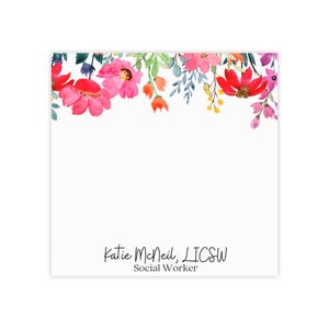 Puede incluir: Una tarjeta blanca con un borde floral en tonos de rosa, rojo y amarillo. El texto "Katie McNeil, LICSW Social Worker" está impreso en negro en la parte inferior de la tarjeta.