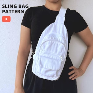 Peut inclure: Un sac à bandoulière blanc uni doté d'un compartiment principal zippé et d'une poche avant zippée plus petite. Le sac possède une large sangle unique et affiche le texte SLING BAG PATTERN avec une icône de bouton lecture rouge en haut à gauche.