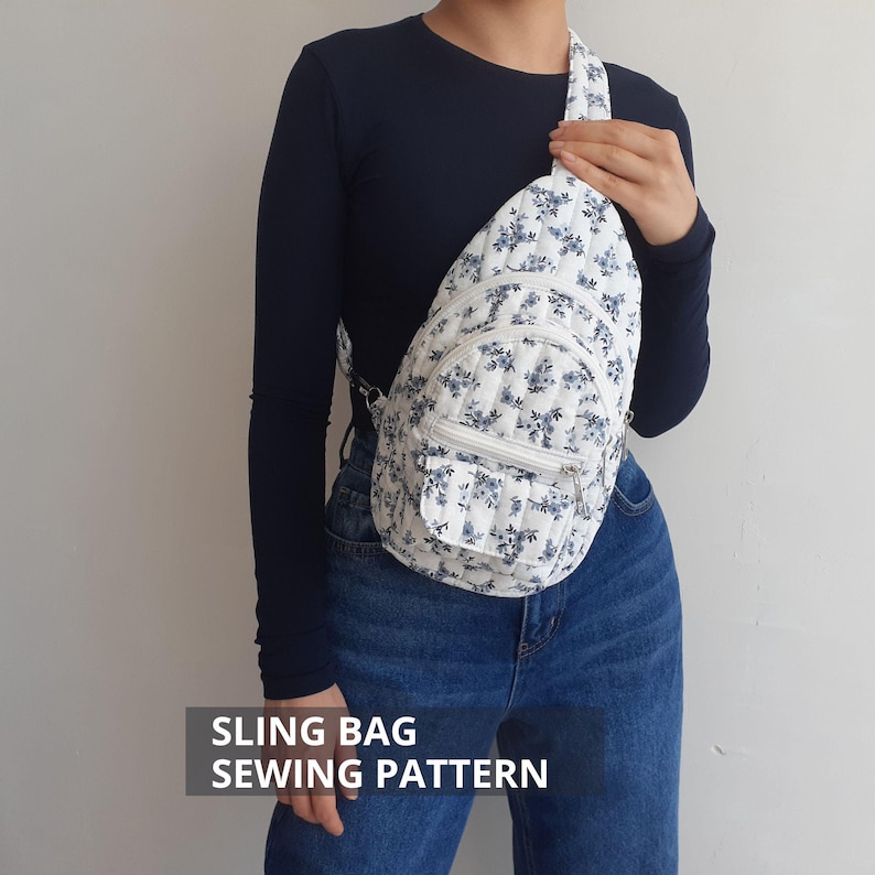 May include: A white sling bag with a blue floral pattern is worn over the shoulder. The bag has a quilted texture, a zippered front pocket, and a matching strap. The text "SLING BAG SEWING PATTERN" is displayed at the bottom.