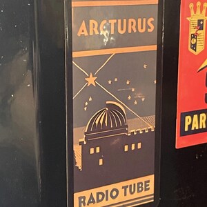 May include: Rectangular magnet with the word "ARCTURUS" in orange letters at the top. The magnet features a night sky scene with a star and constellations above a building with a domed roof. The words "RADIO TUBE" are at the bottom.