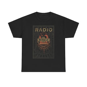 Peut inclure: T-shirt noir avec un graphique vintage de couverture de livre. La couverture présente le texte "RADIO ELECTRA THE MIRACLE OF THE SOUND" en lettres dorées et rouges.