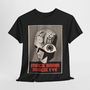 Könnte beinhalten: Schwarzes T-Shirt mit einem Grafikdruck eines stilisierten Kopfes mit einem großen Auge und dem Text "Magic Brain Magic Eye".
