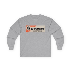 May include: A gray long-sleeve t-shirt with a vintage-style logo for Swan Electronics. The logo is a black and white swan with the text "SWAN ELECTRONICS Oceanside, California" in black.