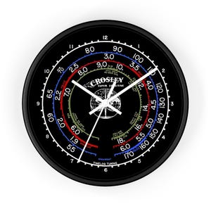 May include: A black and white clock face with a white dial and hands. The clock face has a black background with a white globe in the center. The clock face has a series of concentric circles with numbers and text. The text on the clock face includes "CROSLEY SUPER SENSITIVE" and "TIMELOG TUNING".