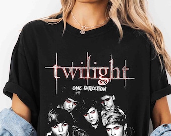 May include: Black t-shirt featuring a graphic of the word "twilight" in a red, stylized font, with the words "ONE DIRECTION" below. The shirt also displays a group of five people. The text "Comfort C. Black" is on the bottom left.