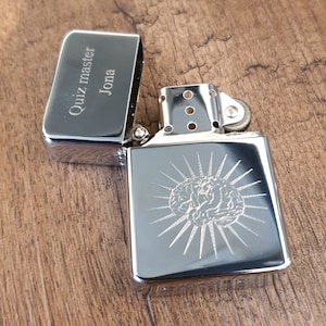 May include: Silver lighter with a brain design engraved on the front. The top of the lighter has the text "Quiz master Jona" engraved on it.