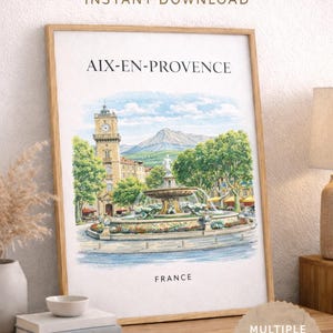 Peut inclure: Illustration à l'aquarelle encadrée d'Aix-en-Provence, France, représentant une fontaine, un clocher et une montagne. L'impression est encadrée dans un cadre en bois clair et porte la mention "Téléchargement instantané". Le mot "France" est également visible.