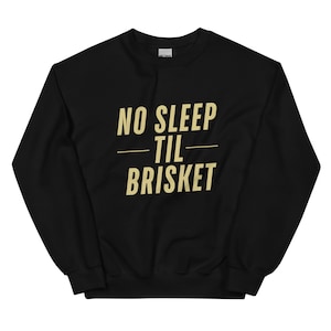 Könnte beinhalten: Schwarzer Pullover mit goldener Aufschrift "NO SLEEP TIL BRISKET".
