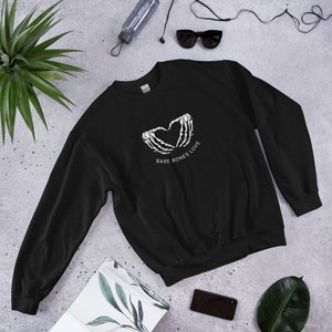 May include: Black sweatshirt with a white graphic of two skeleton hands forming a heart shape with the text "Bare Bones Love" underneath.