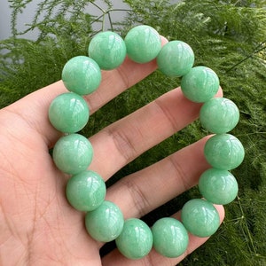 K&ouml;nnte beinhalten: Ein Jade-Armband aus runden Perlen. Das Armband ist aus nat&uuml;rlichem Jade und hat eine sch&ouml;ne gr&uuml;ne Farbe.