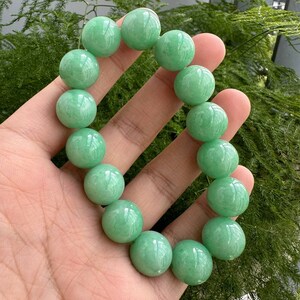 K&ouml;nnte beinhalten: Ein Jade-Armband aus runden Perlen. Das Armband ist aus nat&uuml;rlichem Jade und hat eine sch&ouml;ne gr&uuml;ne Farbe.