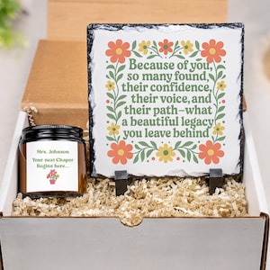 May include: A gift box with a candle and a slate plaque. The plaque has a floral design and the text "Because of you... a beautiful legacy you leave behind." The candle label says "Mrs. Johnson, Your next Chaper Begins here..."