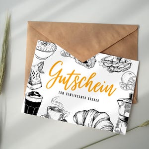 Könnte beinhalten: Eine weiße Karte mit schwarz-weißen Illustrationen von Lebensmitteln, darunter ein Croissant, Kaffee und Obst. Die Karte trägt den Text "Gutschein zum gemeinsamen Brunch" in orange.