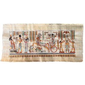 May include: A detailed, colourful papyrus painting depicting an ancient Egyptian scene. The artwork features figures in traditional attire, chariots, and hieroglyphs. The painting is on a beige papyrus background with a black and white border.