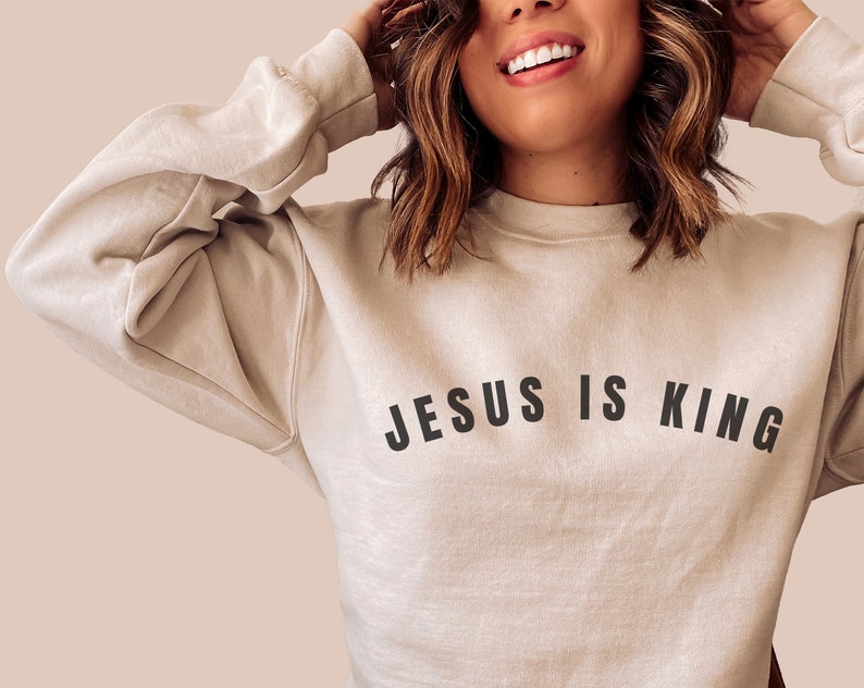 May include: A beige sweatshirt with the text "JESUS IS KING" printed in black.