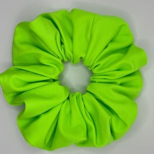 May include: A bright neon green scrunchie made of fabric.