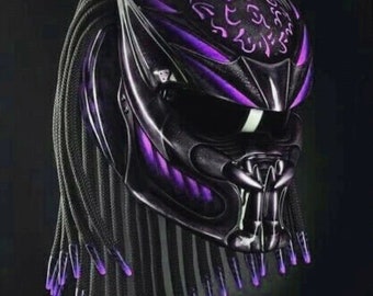 Könnte beinhalten: Ein schwarzer Motorradhelm mit einem violetten Design und schwarzen Dreadlocks. Der Helm hat ein Raubtier-ähnliches Design mit einem Kiefer und Zähnen.