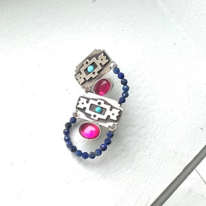 Peut inclure: Un bracelet en argent avec trois pierres roses et turquoise, serties dans des cadres géométriques en argent, et une chaîne de perles bleu foncé.