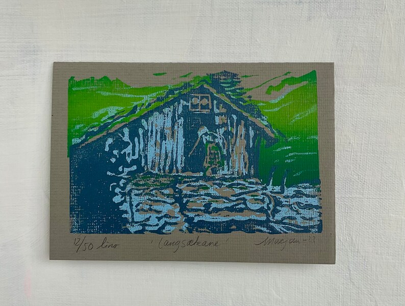 Linocut greeting card with traditional norwegian cabin and woman. Signed and numbered, in colors green blue and lightblue, framed