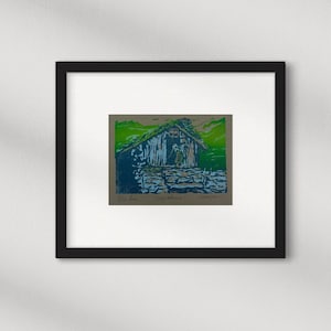 Linocut greeting card with traditional norwegian cabin and woman. Signed and numbered, in colors green blue and lightblue, framed