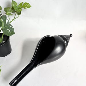 May include: A white ceramic mug with a black handle and the text "But First, Coffee" in a handwritten style. The mug is on a white surface. The mug is approximately 4 inches tall.