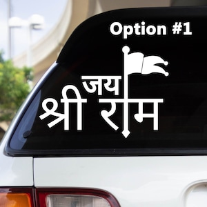 May include: A white vinyl sticker with the text "Jai Shri Ram" and a flag design. The sticker is on the back window of a car.