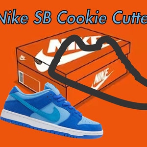 May include: A blue and light blue Nike SB Dunk Low sneaker with a white midsole and a blue outsole. The shoe is sitting on an orange background with a black outline of a Nike shoe box.