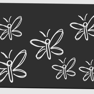 May include: A black rectangular surface with rounded corners features a pattern of five white butterfly illustrations. The butterflies are drawn with simple, sketchy lines, giving them a whimsical appearance. The overall design is clean and minimalist.