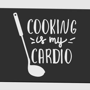 May include: Black rectangular kitchen mat with rounded corners. The mat features a white illustration of a ladle and the phrase "COOKING is my CARDIO" in a handwritten style font.