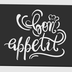 May include: A rectangular black kitchen mat with rounded corners. The mat features the words "Bon app&eacute;tit" in elegant white cursive script, with a chef's hat above the word "bon".