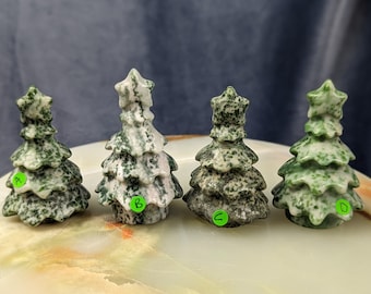 May include: Four green and white speckled stone Christmas tree ornaments. The trees are arranged in a row from left to right, labeled A, B, C, and D.