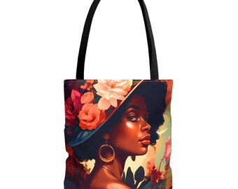 May include: Tote bag featuring a vibrant illustration of a woman wearing a floral hat. The artwork showcases a woman with dark skin, gold hoop earrings, and a red lip. The bag has black handles and a colorful floral background.