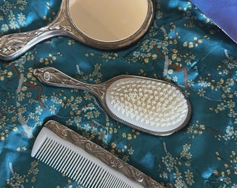 Elegante juego de tocador vintage chapado en plata con cepillo, espejo y peine.
