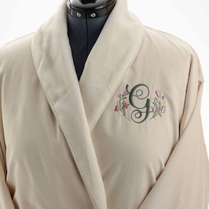 Op de afbeelding: Een witte keramische mok met een zwart handvat en de tekst "But First, Coffee" in een zwarte, vette letter. De mok staat op een wit oppervlak. De mok is 10 cm hoog.