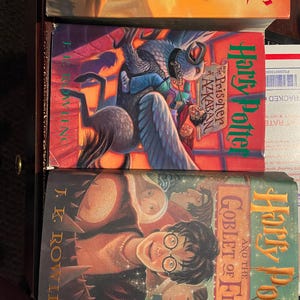 May include: Three hardcover books from the Harry Potter series. The covers feature illustrations of characters and scenes from the books. Titles include "Harry Potter and the Prisoner of Azkaban" and "Harry Potter and the Goblet of Fire."