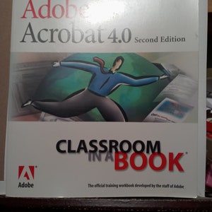 May include: A book cover with a red and white logo for Adobe Acrobat 4.0 Second Edition. The cover features a cartoon illustration of a person in a blue shirt and red tie, jumping over a green globe. The text "Classroom in a Book" is in red and black.
