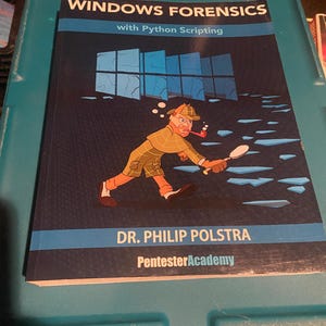 May include: A softcover book titled Windows Forensics with Python Scripting by Dr. Philip Polstra. The dark blue cover features a cartoon detective with a pipe and magnifying glass, walking across blue shattered glass shards under a window icon.