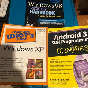 May include: Three technical reference books: Windows 98 Registry Handbook, The Complete Idiot's Guide to Windows XP, and Android 3 SDK Programming for Dummies. The covers feature white, black, blue, orange, and yellow text with various graphics.