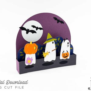 Könnte beinhalten: Ein Halloween-Diorama aus Papier mit einem Kürbis, einem Geist mit Hexenhut und einem Katzengeist, die alle Halloween-Leckereien halten. Die Szene umfasst einen Vollmond, Fledermäuse und einen lila Hintergrund. Der Text lautet "Digital Download SVG Cut File".