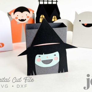 Może przedstawiać: Zestaw pięciu pudełek na słodkości w stylu Halloween. Pudełka mają kształt ducha, wampira, czarownicy, nawiedzonego domu i nietoperza. Pudełka są ozdobione różnymi motywami Halloween. Pudełka są wykonane z kartonu i są gotowe do złożenia.