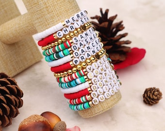 May include: A stack of colorful beaded bracelets with white beads that spell out Christmas-themed words like "Merry", "Christmas", "Santa", "Dasher", "Dancer", "Prancer", "Vixen", "Comet", "Cupid", "Donner", "Blitzen", and "Rudolph".